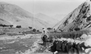 View down from the Dorah Pass Chitral. Elevation 4400 metres (14800 feet). In the middle a newly converted to Islam (sheikh) on horseback. Picture by Georg Morgenstierne, 1929
